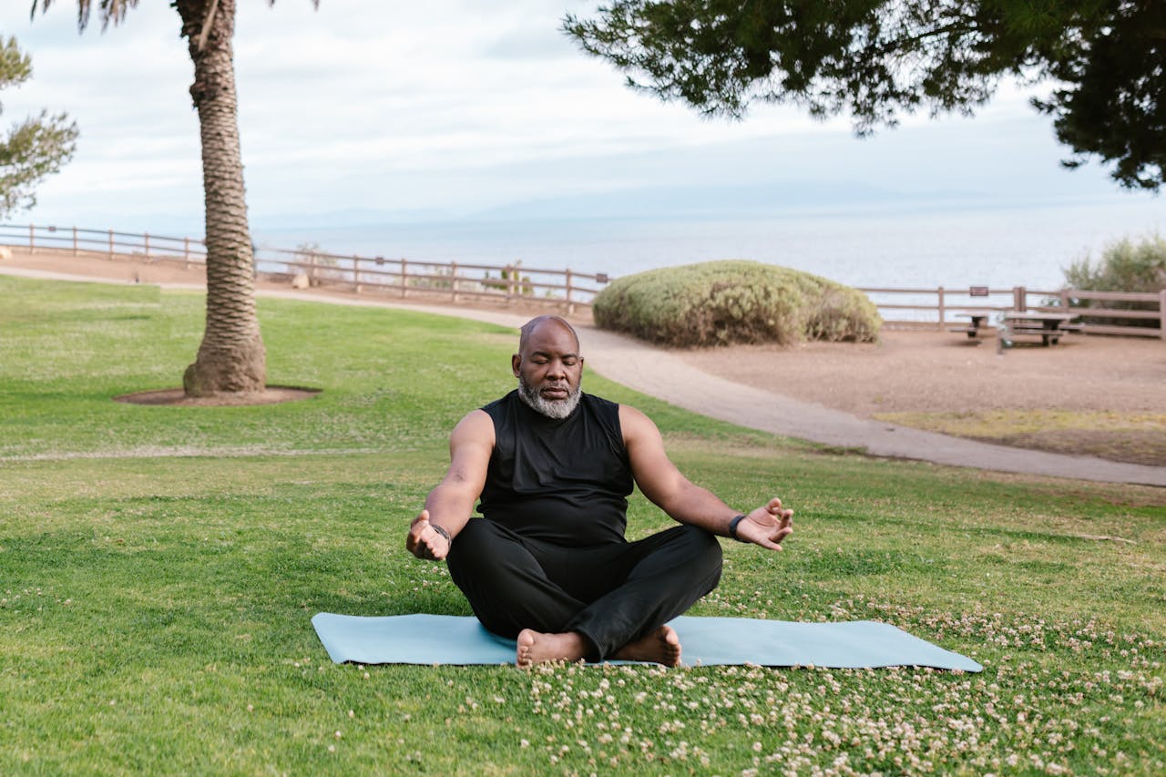 Adult man practicing yoga outdoors by the sea, embracing tranquility and wellness.